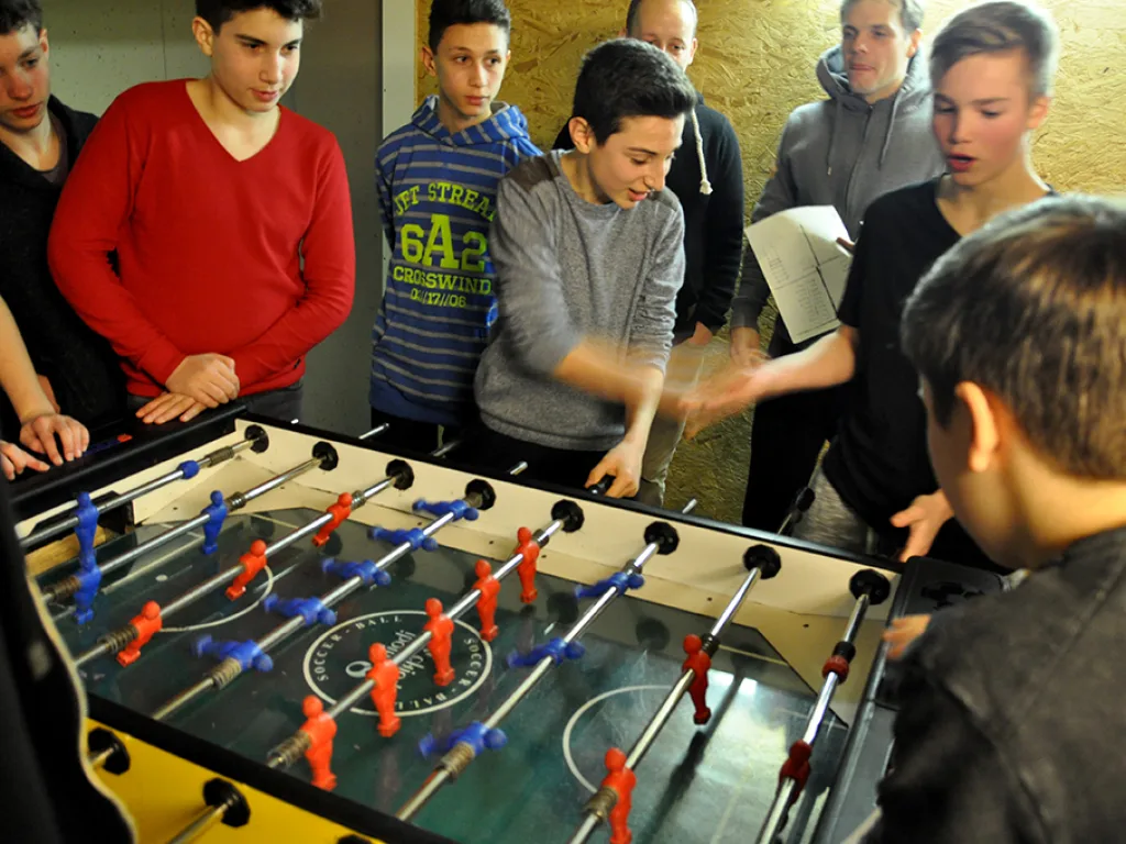 Spannende Partie am Tischfußballtisch mit vielen Zuschauern.